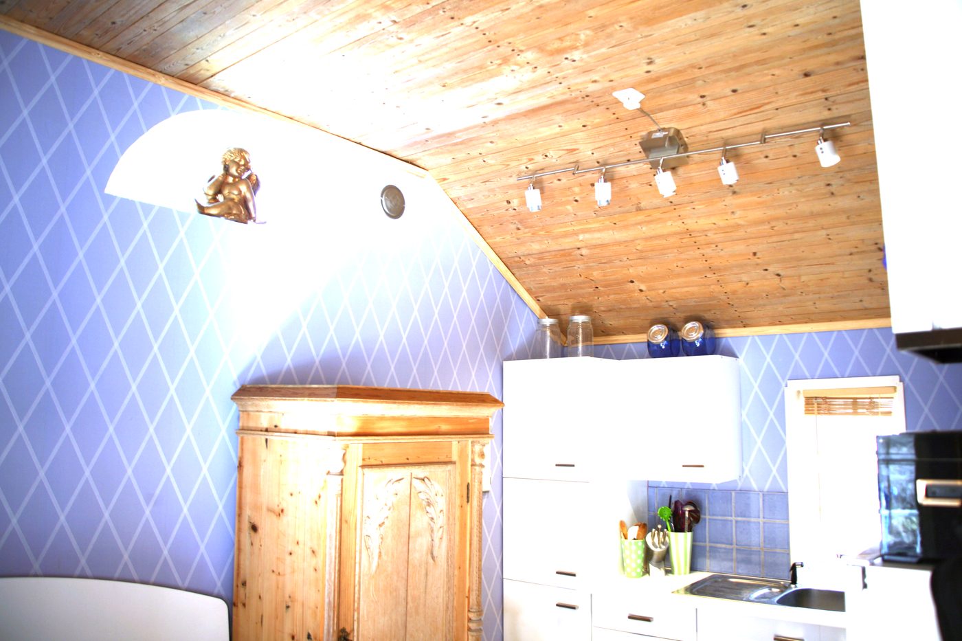 Fully equipped open kitchen under the timber ceiling